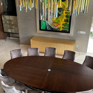 ET2 Flute tube cluster over an oval dining table with gray upholstered chairs and colorful wall art