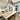 ET2 Flute brass tubes over a long pale dining table with sheer curtained windows behind