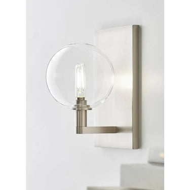 Contemporary brass wall sconce with globe light for entryway or bedroom lighting