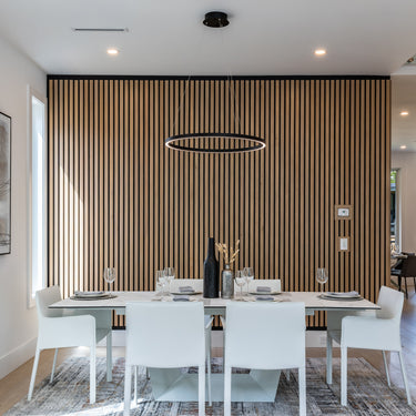 ET2 Groove black LED ring pendant hung over a white-chaired dining table in front of a wood-slat wall