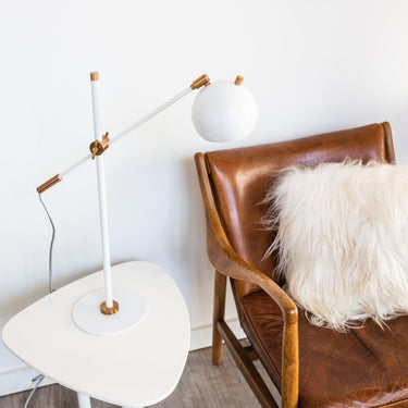 Orwell LED Counterbalance Table Lamp in White with Weathered Brass Accents styled in a lived-in room – House of Troy