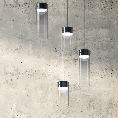 ET2 Highball glass cylinder pendants with dark caps hung at different heights in front of a gray concrete wall