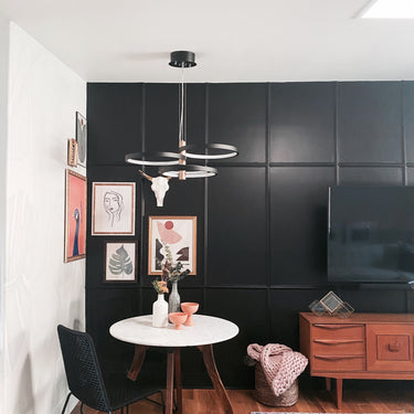ET2 Hoopla multi-ring pendant in black over a small round table against a dark paneled wall