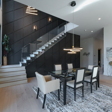 ET2 Hoopla multi-ring pendant over a glass dining table beside an open staircase