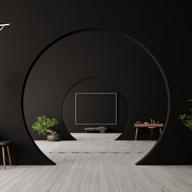 ET2 Hover thin black baton pendants floating in front of a black round feature wall in a dark living room