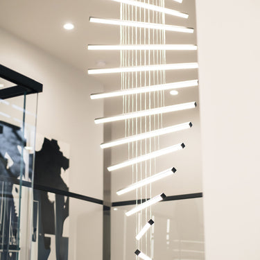 ET2 Hover glowing baton pendants stacked in a spiral down a tall stairwell