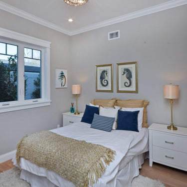 ET2 Inca flush mount in a bedroom with a gold throw on the bed and framed prints