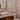 ET2 Inca flush mount reflected in a gold-framed mirror above a vessel sink in a powder room