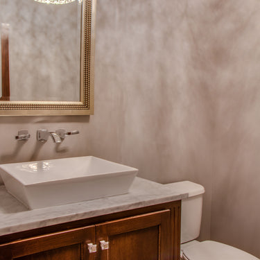 ET2 Inca flush mount reflected in a gold-framed mirror above a vessel sink in a powder room