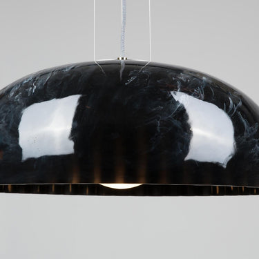 Innermost Doric 60 LED pendant light in polished black marble finish, hanging over a modern dining table.