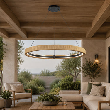ET2 Kaia rattan-wrapped ring pendant hanging on a covered patio over outdoor sofas and a lounge area