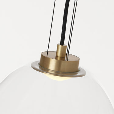 Clear glass hanging light with natural brass detail for kitchen task lighting or restaurant interiors