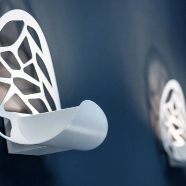 Kelly wall sconce by Lodes in matte white with laser-cut geometric design and warm LED lighting