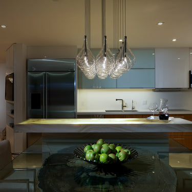 ET2 Larmes teardrop pendants in a cluster over a glass-top table in an open kitchen with stainless appliances