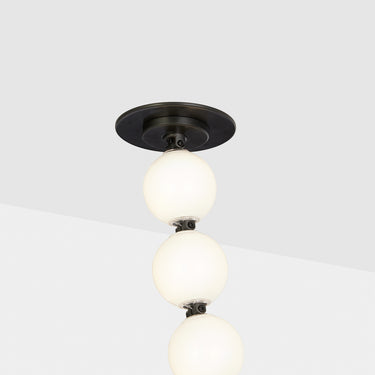 Modern vertical chandelier with glass orbs and dark bronze structure