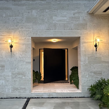 Lyndon outdoor wall lamp by Oluce flanking a front entry, lifestyle view