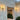 Lyndon outdoor wall lamp by Oluce beside a courtyard entrance, lifestyle view