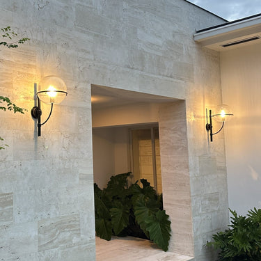 Lyndon outdoor wall lamp by Oluce beside a courtyard entrance, lifestyle view