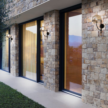 Lyndon 161 mini outdoor wall lamp by Oluce mounted on a building facade, lifestyle view