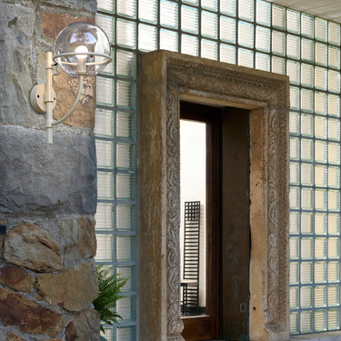Lyndon 161 mini outdoor wall lamp by Oluce beside a glass-block doorway, lifestyle view