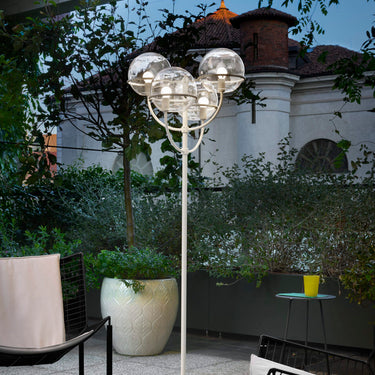 Oluce Lyndon 351 outdoor floor lamp beside a lounge chair on a patio