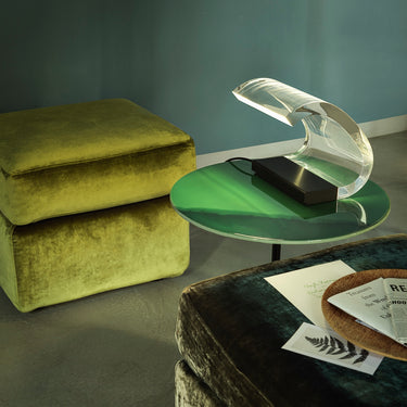 Oluce Acrilica lamp on a table with green velvet cushions