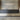 ET2 Manta large linear pendant hung above a black reception desk in a lobby with wood slat walls