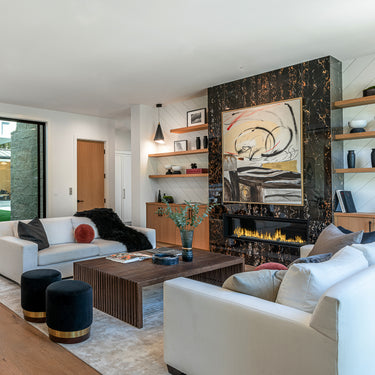 ET2 Mermaid black and gold cone pendants hung near the wall of a living room with white sofas and a dark marble fireplace