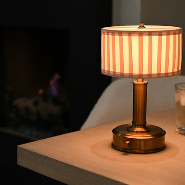 Mini Tito Cordless Table Lamp Dark Antique Brass Pleated Shade on desk