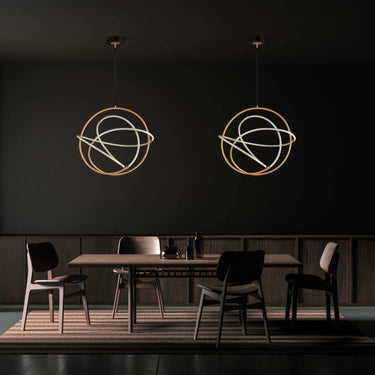 Pair of ET2 Mobius loop pendants with brass hoops hanging over a dark dining room table