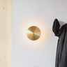 Modern hallway featuring Graypants Chrona round brass sconce - residential lighting idea.