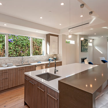 ET2 Nucleus clear glass orb pendants hanging over a kitchen island with white stools