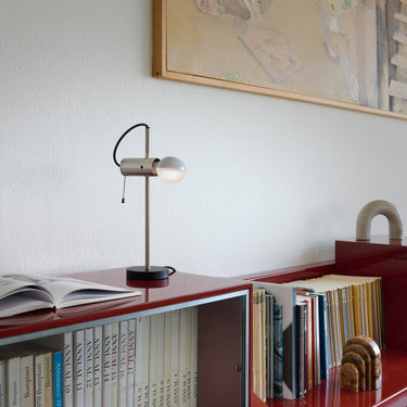 Agnoli table lamp on a shelf beside books in a styled interior