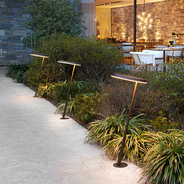 Row of Oluce Amanita 319 path lights along a garden walkway at dusk