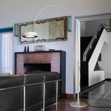 Oluce Berlin-Out arched floor lamp in a living room with a fireplace and mirror