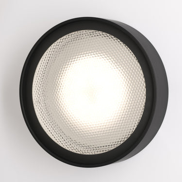 Oluce Berlin-Out round wall lamp in matt black with a textured acrylic disc on a white background