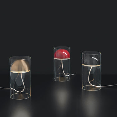 Three lit Oluce Medusa table lamps in black against a dark background