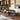 Oluce Spider floor lamp beside a leather sofa in a library setting