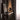 Oluce Superluna table lamp on a dark console by a curtain