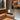 Oluce Superluna table lamp beside a leather sofa and shelves