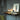 Oluce The Globe table lamp lit on a console table beside books