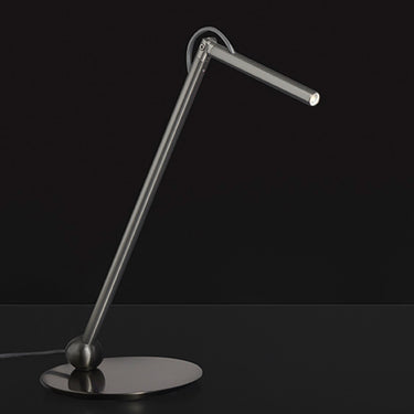 Oluce Calamaio satin black nickel desk lamp with angled arm, studio view on a dark background
