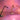 Three Oluce Calamaio LED desk lamps glowing against a pink-lit backdrop