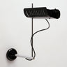 Oluce Colombo wall lamp in black with a chrome arm and ribbed reflector on a white studio background