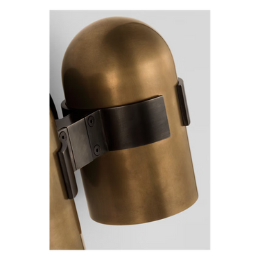 Designer brass wall sconce with curved metal shade and 2700K warm LED glow