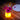 Olio Bluetooth LED Cordless Lamp by Smart & Green glowing yellow as a flower vase with magenta gerberas on a wood table - LoftModern