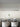 Ilo horizontal pendant by Oluce hung over a long dark dining table with white armchairs