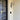 Lyndon outdoor wall lamp by Oluce beside a front door, lifestyle view