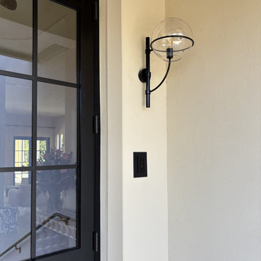 Lyndon outdoor wall lamp by Oluce beside a front door, lifestyle view