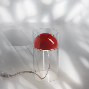 Oluce Medusa table lamp in scarlet red with a metal dome inside a clear glass cylinder